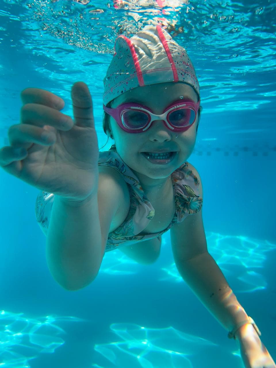 Una niña feliz nadando en una piscina